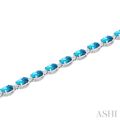 7X5 MM Oval Shape Blue Topaz and 1/10 Ctw Round Cut Diamond Semi-Precious Bracelet in Sterling Silver
